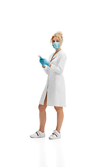 Image showing Portrait of female doctor, nurse or cosmetologist in white uniform and blue gloves over white background