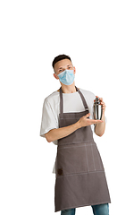 Image showing Isolated portrait of a young male caucasian barista or bartender in brown apron smiling