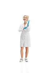 Image showing Portrait of female doctor, nurse or cosmetologist in white uniform and blue gloves over white background