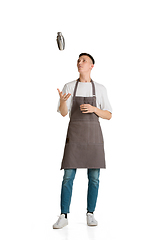 Image showing Isolated portrait of a young male caucasian barista or bartender in brown apron smiling