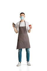 Image showing Isolated portrait of a young male caucasian barista or bartender in brown apron smiling