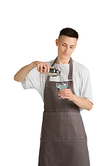 Image showing Isolated portrait of a young male caucasian barista or bartender in brown apron smiling