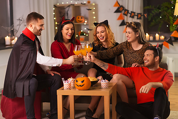 Image showing happy friends in halloween costumes at home party