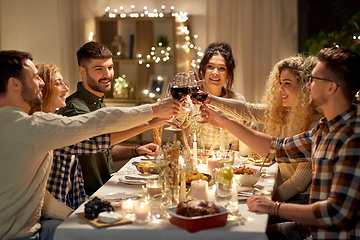 Image showing happy friends drinking red wine at christmas party