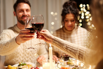 Image showing happy friends drinking red wine at christmas party