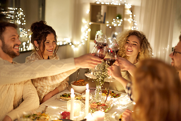 Image showing happy friends drinking red wine at christmas party