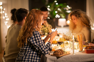 Image showing woman with smartphone at dinner party with friends