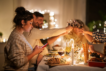 Image showing woman with smartphone at dinner party with friends