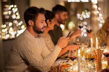 Image showing man with smartphone at dinner party with friends