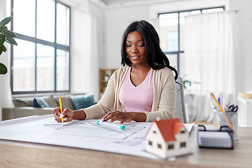 Image showing female architect with house model and blueprint