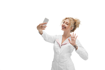 Image showing Portrait of female doctor, nurse or cosmetologist in white uniform and blue gloves over white background