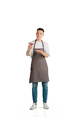 Image showing Isolated portrait of a young male caucasian barista or bartender in brown apron smiling