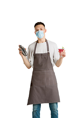 Image showing Isolated portrait of a young male caucasian barista or bartender in brown apron smiling