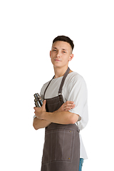 Image showing Isolated portrait of a young male caucasian barista or bartender in brown apron smiling