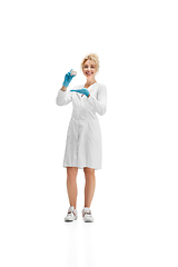 Image showing Portrait of female doctor, nurse or cosmetologist in white uniform and blue gloves over white background