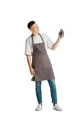 Image showing Isolated portrait of a young male caucasian barista or bartender in brown apron smiling