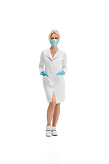 Image showing Portrait of female doctor, nurse or cosmetologist in white uniform and blue gloves over white background