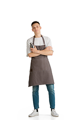 Image showing Isolated portrait of a young male caucasian barista or bartender in brown apron smiling