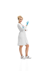 Image showing Portrait of female doctor, nurse or cosmetologist in white uniform and blue gloves over white background