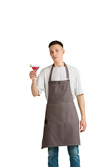 Image showing Isolated portrait of a young male caucasian barista or bartender in brown apron smiling