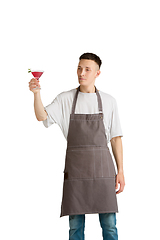 Image showing Isolated portrait of a young male caucasian barista or bartender in brown apron smiling