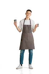 Image showing Isolated portrait of a young male caucasian barista or bartender in brown apron smiling