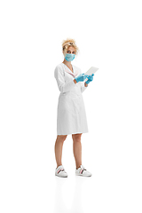 Image showing Portrait of female doctor, nurse or cosmetologist in white uniform and blue gloves over white background