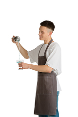 Image showing Isolated portrait of a young male caucasian barista or bartender in brown apron smiling