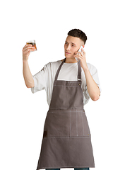 Image showing Isolated portrait of a young male caucasian barista or bartender in brown apron smiling