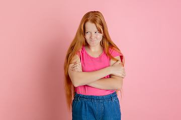 Image showing Caucasian teen girl\'s portrait isolated on coral pink studio background.