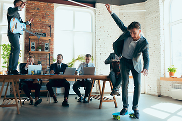 Image showing Happy colleagues having fun in office while their colleagues working hard