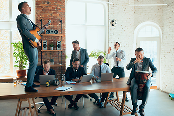 Image showing Happy colleagues having fun in office while their colleagues working hard