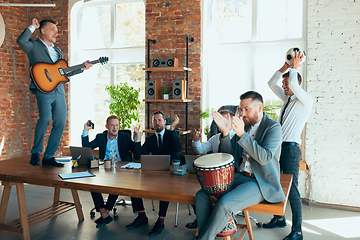 Image showing Happy colleagues having fun in office while their colleagues working hard