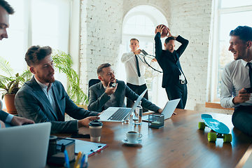 Image showing Happy colleagues having fun in office while their colleagues working hard