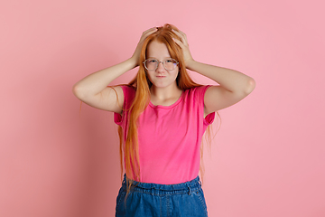 Image showing Caucasian teen girl\'s portrait isolated on coral pink studio background.