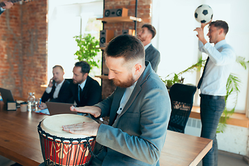 Image showing Happy colleagues having fun in office while their colleagues working hard