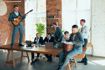 Image showing Happy colleagues having fun in office while their colleagues working hard