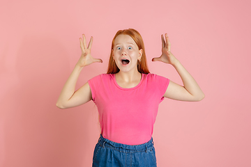 Image showing Caucasian teen girl\'s portrait isolated on coral pink studio background.