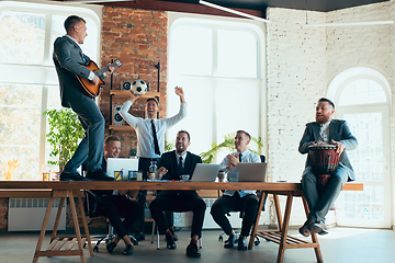 Image showing Happy colleagues having fun in office while their colleagues working hard