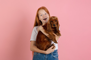 Image showing Caucasian teen girl\'s portrait isolated on coral pink studio background.