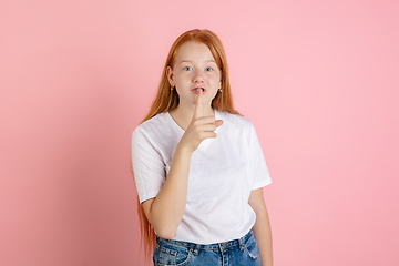 Image showing Caucasian teen girl\'s portrait isolated on coral pink studio background.