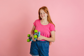 Image showing Caucasian teen girl\'s portrait isolated on coral pink studio background.