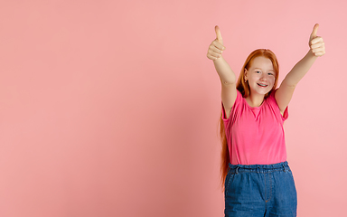 Image showing Caucasian teen girl\'s portrait isolated on coral pink studio background.