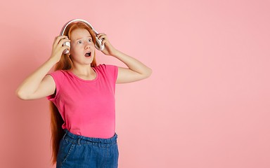 Image showing Caucasian teen girl\'s portrait isolated on coral pink studio background.