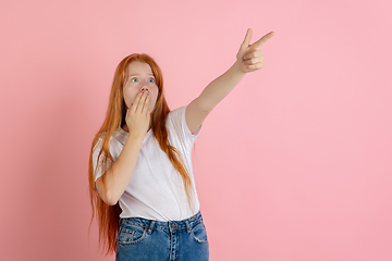 Image showing Caucasian teen girl\'s portrait isolated on coral pink studio background.