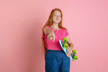 Image showing Caucasian teen girl\'s portrait isolated on coral pink studio background.