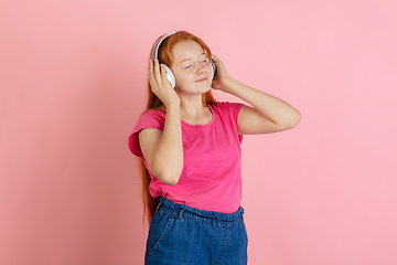 Image showing Caucasian teen girl\'s portrait isolated on coral pink studio background.