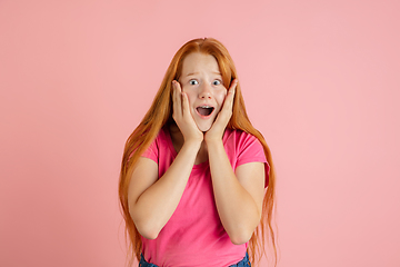 Image showing Caucasian teen girl\'s portrait isolated on coral pink studio background.