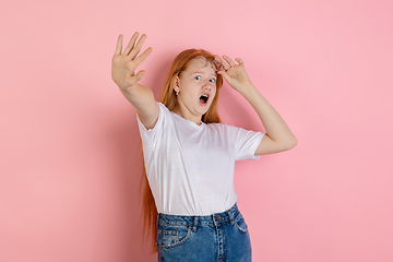 Image showing Caucasian teen girl\'s portrait isolated on coral pink studio background.