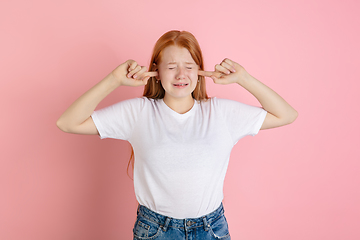 Image showing Caucasian teen girl\'s portrait isolated on coral pink studio background.